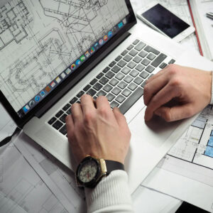 Un arquitecto trabajando en un plano con un cliente, simbolizando la necesidad de asesoría profesional.