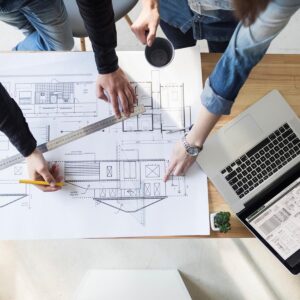 Arquitectos trabajando en planos, representando los servicios de un estudio de arquitectura.